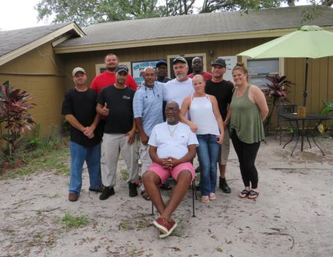 Henry Green sits surrounded by some of the people he has helped through the Grace and Gratitude Sober Living program. He and Dr. Jeff Blyth are both recovering addicts and fighting the city of Fernandina Beach to keep the four houses that comprise Grace and Gratitude’s facilities open. JULIA ROBERTS/NEWS-LEADER