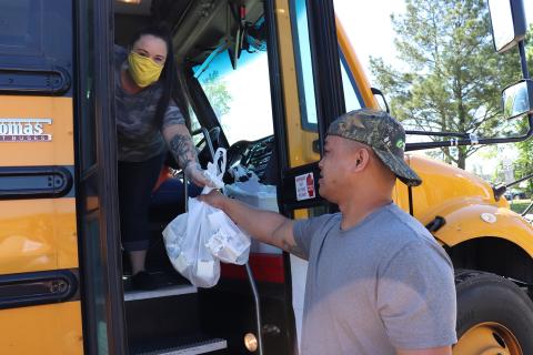 Callahan resident Bobby Llanes collects breakfast and lunch items from Bethany Low during a Nassau County School District meal distribution Friday morning near Amhurst Oaks subdivision. 