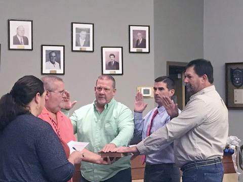 Hilliard town councilmen Kenny Sims, Jared Wollitz and Lee Pickett take the oath of office as Town Clerk Lisa Purvis officiates while Council President John Beasley holds a Bible.