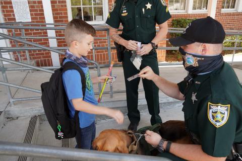 Callahan Elementary School students visit K-9 officers as they depart for spring break March 19. The Nassau County Sheriff’s Office bloodhounds visited the students, with their handlers giving out collectible K-9 cards.
