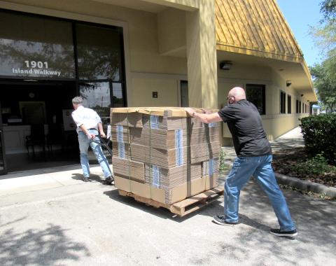 Nassau County Council on Aging Transportation Director Mike Hays and volunteer Philip Chapman roll a pallet of WestRock-donated boxes into the Fernandina Beach Life Center.