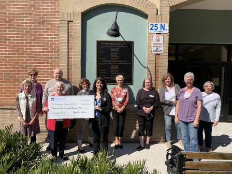 Friends of Fernandina Beach Library President Jody Mackle, front row, from left, presents the group’s annual gift to Nassau County Library Director Dawn Bostwick. Back row: Other board members attending the event were Terri Dean, Joan Sheppard, Chuck Comeau, Ann Freeman, Mary Louise Hester, Christine Meehan, Claudia Zane, Vicki Harnage Whittemore and Margaret Bellucci. Board members not pictured: Hope Foley, Ann Martin, Virgina Mealing and Sara Moerman. 
