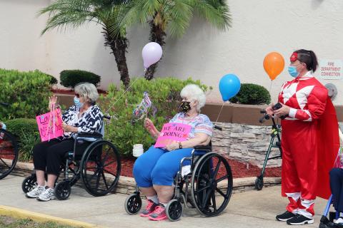 Families, friends and health professional participate in a community parade through the Life Care Center of Hilliard campus Friday morning. Citizens created posters and decorated vehicles with greetings to show their love to residents as they sat outside or stood inside near windows and waved to motorists. 