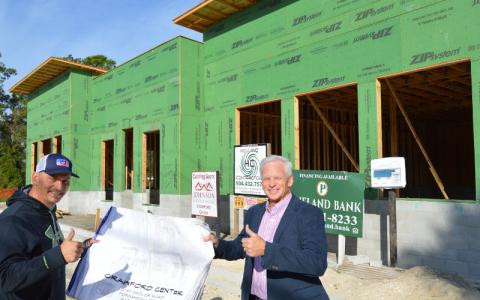 Crawford Jewelers owner Gary Crawford, right, holds up construction plans of The Palms, a 4,200-square-foot shopping center being constructed on Sadler Road. Holding up the plans are Steve Johnson with Johnson Home Builders of Fernandina Beach. JOHN SCHAFFNER/FOR THE NEWS-LEADER