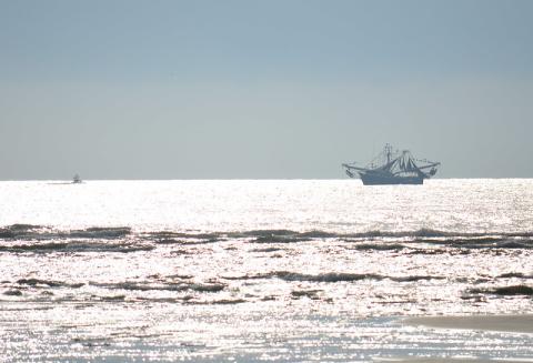 A recreational fishing boat shares the ocean with a commercial shrimp boat.  Florida Fish & Wildlife Conservation Commission