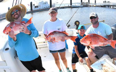 William Boyle, Julie, Breck and William Benton with a nice catch of red snapper, left. Capt. Bryce Schmidt cleans a nice catch of red snapper, right. TERRY LACOSS/SPECIAL