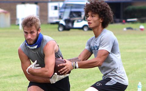 Cam Miller hands off to John Kenny Flood, right, during workouts Monday at Fernandina Beach High School. The season kicks off Monday with practices, and the FBHS Pirates open the season Sept. 4 at Yulee. BETH JONES/NEWS-LEADER