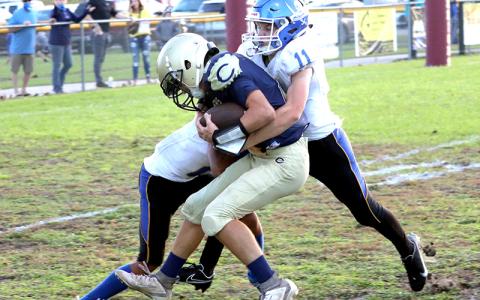 Fernandina Beach Middle School’s Devin Murray and Alex Pulwicz wrap up a Callahan Middle School football player Tuesday night in Callahan. AMANDA REAM/COMMUNITY NEWSPAPERS INC.
