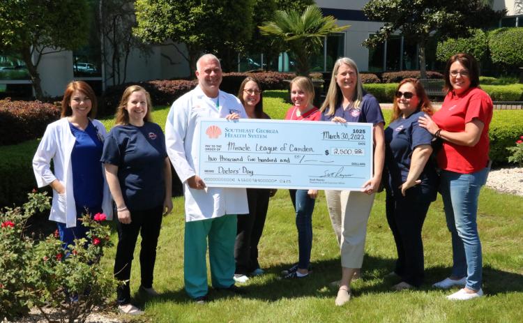Southeast Georgia Health System’s Camden Campus Patient Care Services Jessica Wildes and Medical Staff Chief Dr. Thomas C. Whitesell Jr. participate in a check-passing with Miracle League representatives Ashley Lacoste, Erica Boyd, Cassey McCutcheon, Sarah Johnsen, Tish Fredericks and Mollie Norman.
