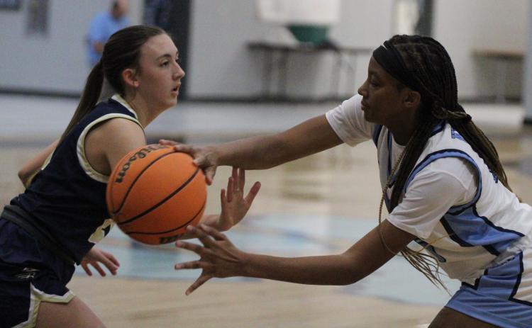 The Lady Wildcats’ Dasmine Cooper tries to pass around a Brantley County defender in a preseason scrimmage. (Andy Diffenderfer, Tribune & Georgian)