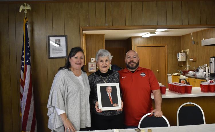 Suzanne M. Johnson, Mary McCollum and Butch Livingstone hold up a photo of Jimmy McCollum, for whom the American Legion Post 170 was named after during a ceremony Saturday.