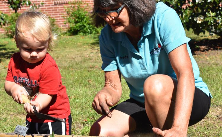 Bart Meyer, helps Freda Malphurs during the unveiling of the St. Marys Public Library’s new community garden.