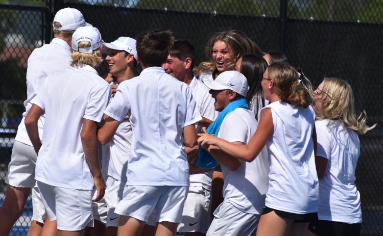 Wildcat tennis players celebrate last Friday after Tyler Klein won the deciding match at No. 3 singles and sealed the boys’ 3-2 second-round Class 7A playoff win over Parkview. (Andy Diffenderfer, Tribune & Georgian)