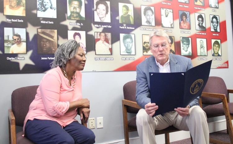 Thiokol Memorial Project CEO and President Jannie Everette, left, listens as state Sen. Michael Hodges (R-Brunswick) reads a resolution memorializing the 30 Woodbine Thiokol Chemical Plant employees who died during the Vietnam War.