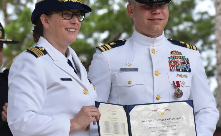 Capt. Kristen Serumgard, chief of the U.S. Coast Guard Atlantic Area Operational Forces, honors Lt. Cmdr. Mark Ketchum, who led the Maritime Safety and Security Team Kings Bay.