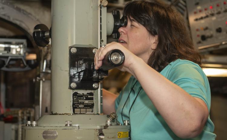 3M Senior Vice President and Global Chief Information Security Officer Carolann Shields looks through the periscope of the Ohio-class ballistic missile submarine USS Wyoming (SSBN 742) during a tour as part of the Joint Civilian Orientation Conference.