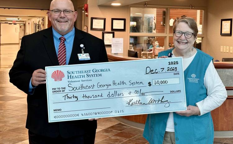 Southeast Georgia Health System Camden Campus Vice President and Administrator Glenn Gann, left, accepts a $30,000 donation from Volunteer Services President Kathleen Worthing.