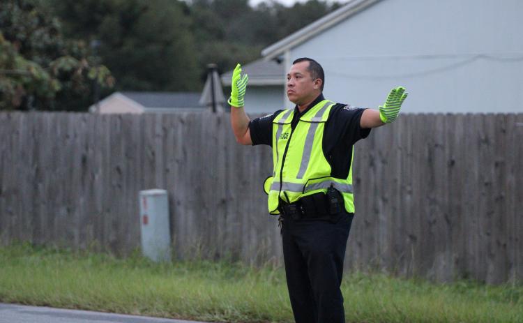 St. Marys Police Department officer Felipe Rivas directs traffic Wednesday morning in front of St. Marys Middle School. Rivas is the school resource officer and works on campus every day.