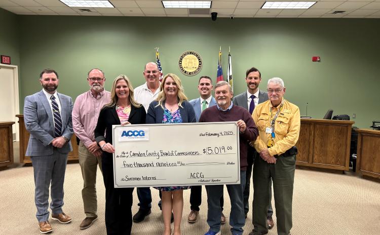 Camden County Administrator Shawn Boatright, from left, Commissioner Robbie Cheek, Communications Director Kristen Kennedy, Chairman Ben Casey, Grants Manager Julie Haigler, Commissioners Cody Smith and Martin Turner, Deputy County Administrator Seth Collins and Commissioner Jim Goodman show off a grant the county received for its internship program.