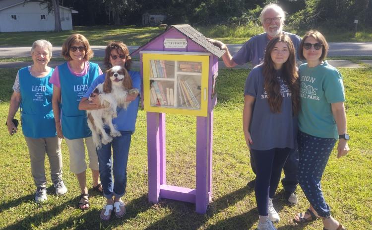 A Little Free Library is located at Woodbine Pharmacy. From left are Janet Heath, Colleen Weinkle, Mickey Silva, Crissy Carter and Ken Duke.