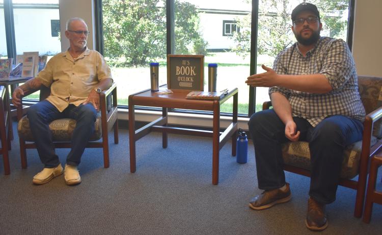 Author Joshua Sharpe, right, talks about his research that helped lead to the exoneration of Dennis Perry, left, who was convicted in the 1985 double murder of Harold and Thelma Swain at Rising Daughter Baptist Church.