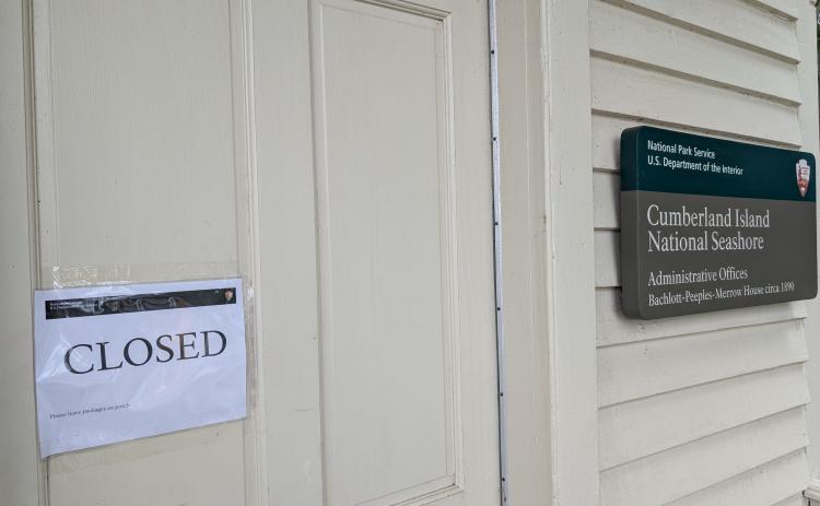 A sign outside the National Park Service’s St. Marys office has a closed sign. Because of the federal government shutdown, Cumberland Island is also not open.