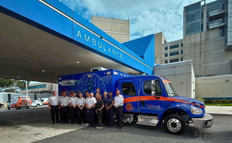 Camden County Fire Rescue and Jacksonville Fire Rescue Department personnel stand in front of the Mobile Stroke Unit.