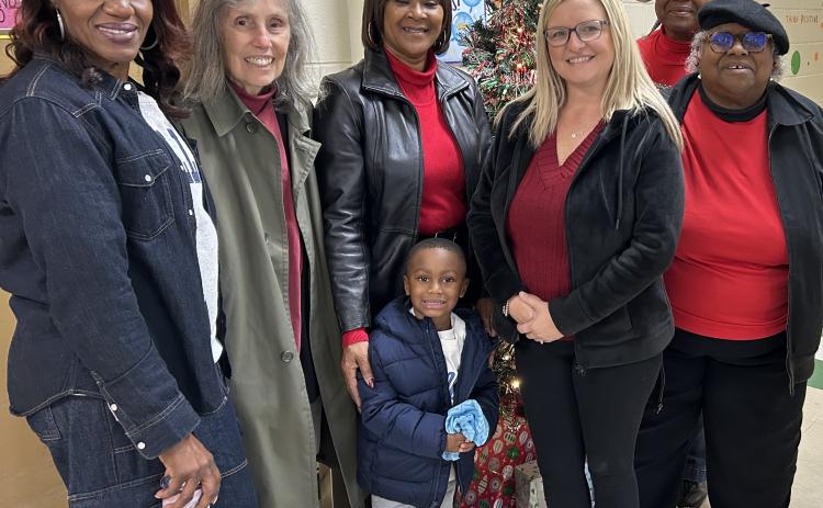 Women United International members pose for a photo with Camden Head Start Program Director Christy Overby after distributing bedtime bags.