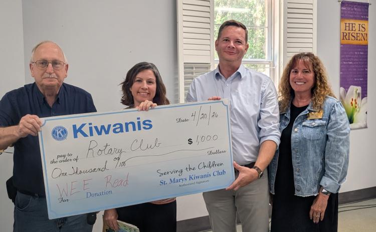St, Marys Kiwanis Club President Dale Law, from left, Rotary Club of Camden County Service Committee Chairwoman Amanda Blyler, Rotary President Mitch Blyler and retired educator Cheryl Alston hold up a check from the Kiwanis Club supporting the Wee Read Program.