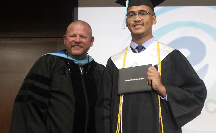 Coastal Plains High School graduate Jayden Hardy, right, shows off his diploma holder with site director Derek Chastain on Thursday night during the program’s commencement exercises at Camden County High School.