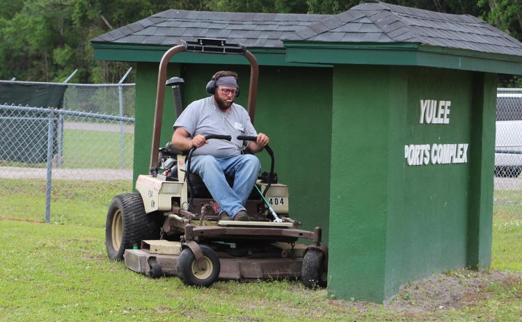 Nassau County’s Shaun Maguire mows grass at the Yulee Sports Complex on Thursday morning.