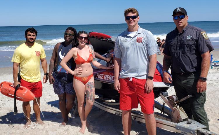 Fernandina Beach Fire Chief Ty Silcox looks on as two kayakers raise their arms in the air after returning to shore Friday, the day Nassau County beaches reopened to the public. Ocean Rescue Lifeguard Spencer Cutajar, seen in the water with a flotation device, along with Ocean Rescue Supervisor Haynes Cavender and NCSO Deputy Garth Holton responded to calls that the kayakers were in trouble. TERRY EBERLE/SPECIAL TO THE NEWS-LEADER