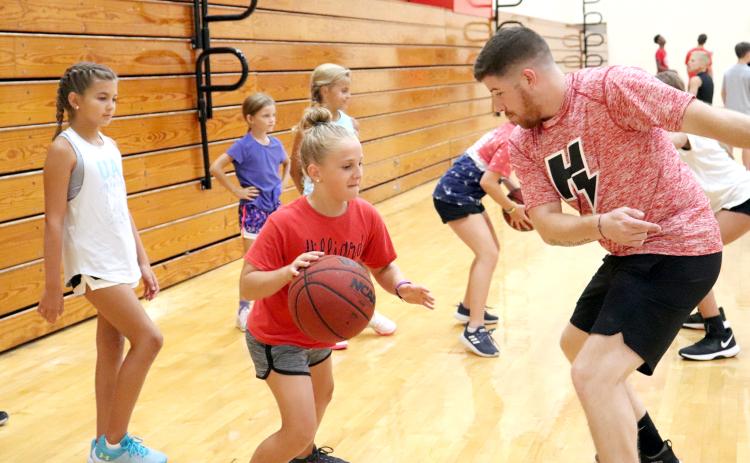 Children ages 7-12 hone their basketball drills as part of the Camp Saunders activities hosted by Hilliard Middle-Senior High School Coach Myron Saunders and the Class 1A state runner-up Flashes boys basketball team in the gym July 15. Forty-four kids participated in the four-day camp, learning the proper way to dribble the ball, defensive tactics and how to hone their skills at the basket. The campers received participation certificates at the conclusion of the camp. 