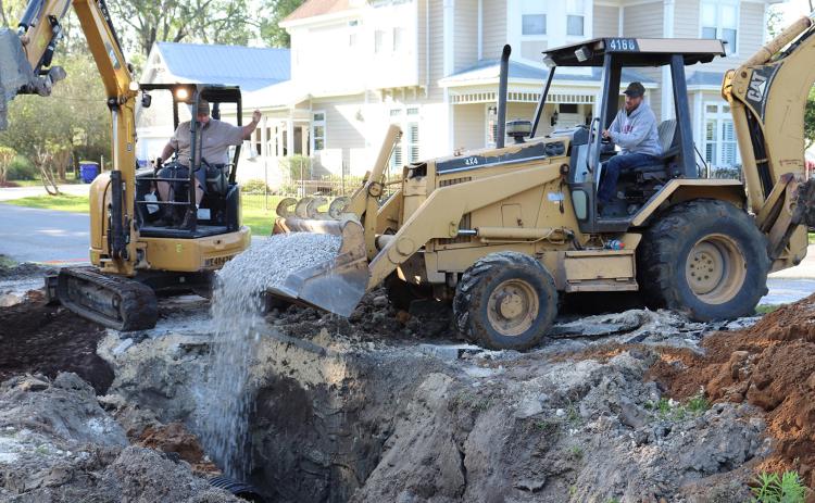 Callahan Public Works employee Ryan Everly unloads gravel recently near water and sewer lines along Dixie Avenue as co-worker Marty Johnson directs him. Photo by Kathie Colgrove