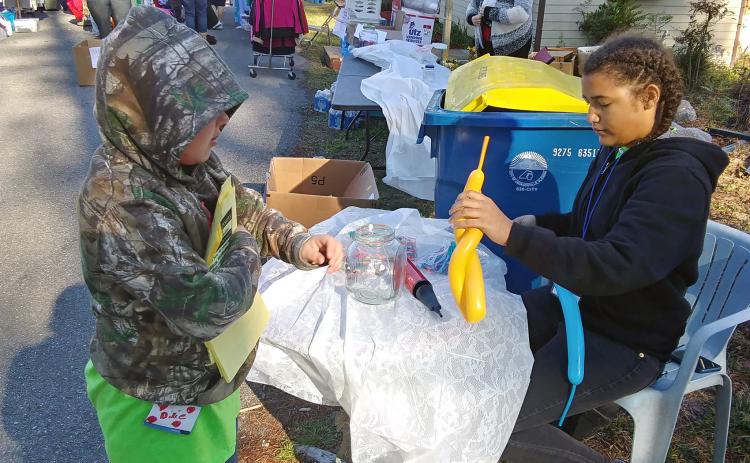 Cousins Dixie Conekin and Aliya Works volunteer at the Be the Change Northeast Florida, Inc. clothing giveaway Saturday. The duo assists at the non-profit’s events often.