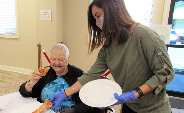 Nassau County Council on Aging’s dietician, Madeline Donovan, serves pizza to Gail Wagner.