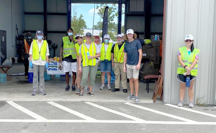 Keep Nassau Beautiful staff and volunteers gather in the shade. They collected hazardous waste from 538 residents Aug. 15. The residents who participated also donated a total of half a ton of non-perishable food items for the Barnabas Food Pantry.