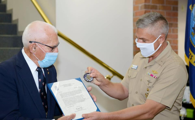Rear Adm. John Spencer, commander, Submarine Group 10, presents Chief Fire Control Technician Richard Henry (retired) with a flag, letter and coin in celebration of his 100th birthday on behalf of Master Chief Petty Officer of the Navy Russell Smith.  SUBMITTED