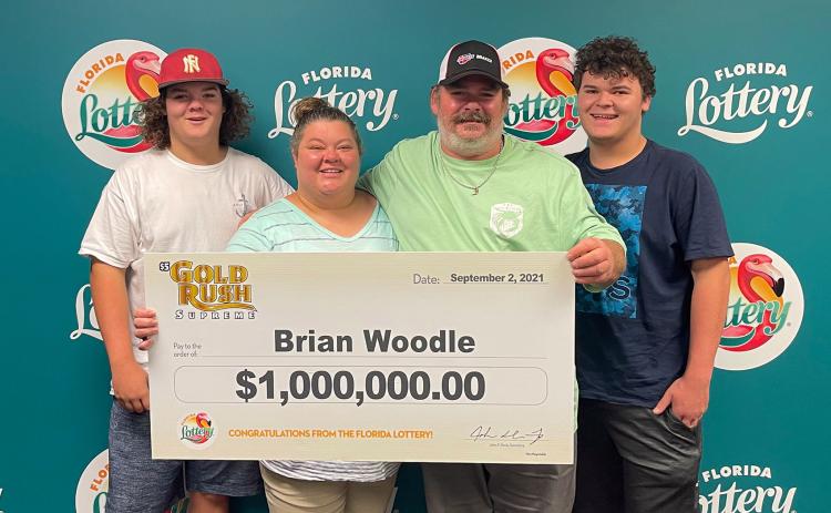 Brian Woodle poses for a photo with his family after winning $880,000 from the Florida Lottery with a Gold Rush Supreme scratch-off ticket.