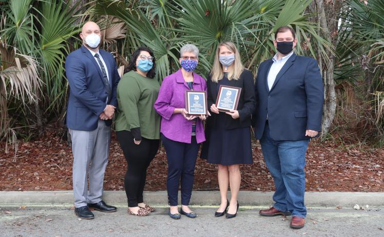 Nassau County Manager Taco Pope, from left, Planning and Economic Opportunity Department Planner/GIS analyst Abby Weiss, Planning and Zoning Board member Linda Morris, Northeast Florida Regional Planning CEO Beth Payne and Nassau County Board of County Commissioners Chairman Thomas Ford pose with the two leadership awards the county received.