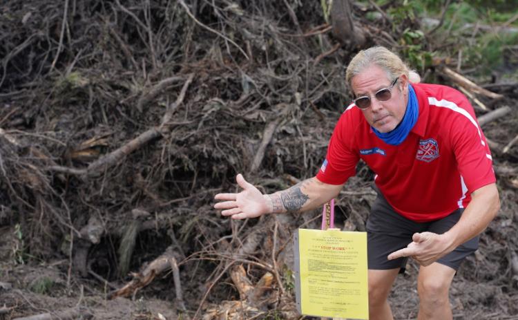 SUBMITTED photos Flora Parke resident Alan “Hupp” Huppmann points to a stop work order issued by the county after a crew began clearing land near his home. Huppmann was just one of the neighbors alarmed by the activity. SUBMITTED