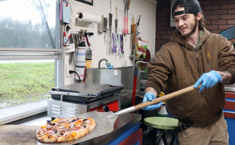 Krusty Kraken’s Austin Downing prepares to box an oven-baked pizza.