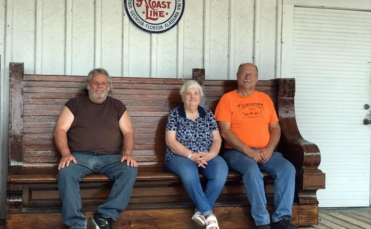 West Nassau Historical Society members Jerry Peterson, from left, Emily Baumgartner and John Hendricks take a break at the Callahan Depot on one of two restored benches that were once part of the Jacksonville Union Terminal waiting area in 1919. Dorothy Higginbotham donated the benches. 
