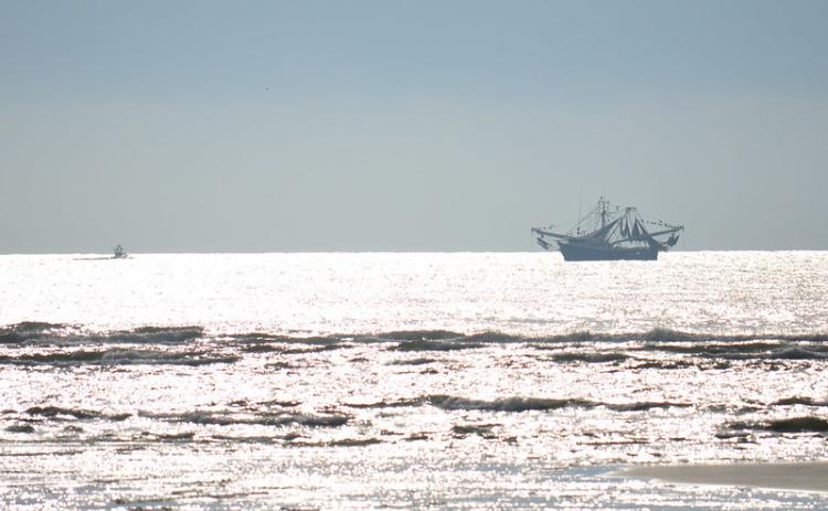 A recreational fishing boat shares the ocean with a commercial shrimp boat.  Florida Fish & Wildlife Conservation Commission