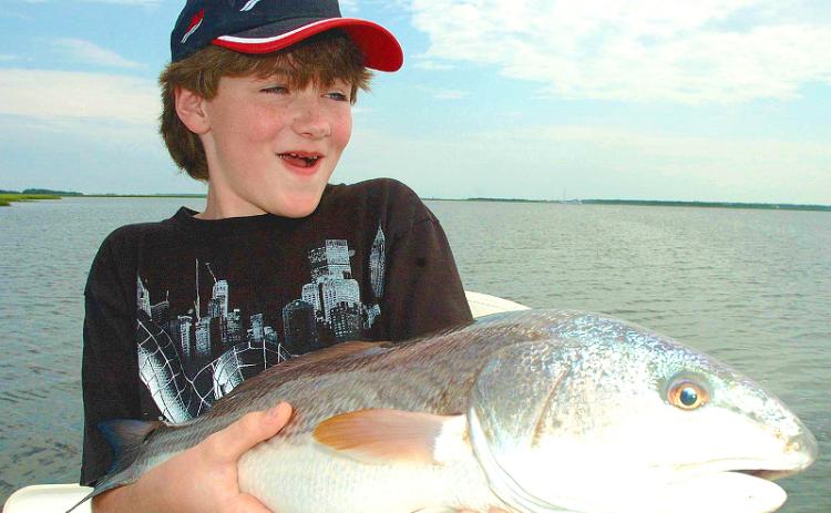 Caleb Goyette is all smiles after catching this big Amelia Island redfish. TERRY LACOSS/SPECIAL