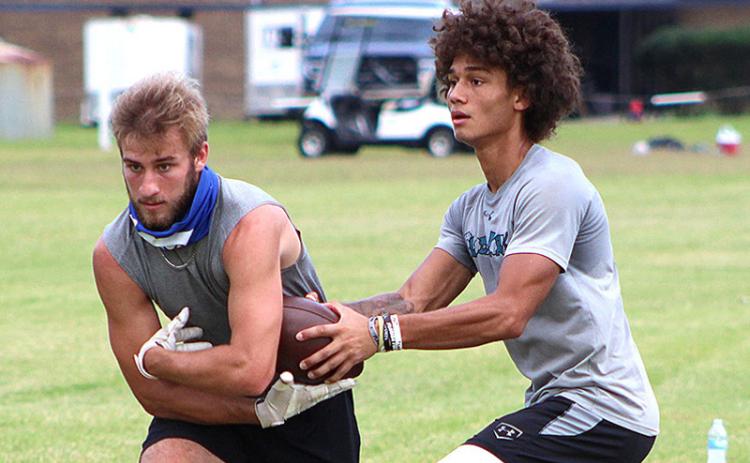 Cam Miller hands off to John Kenny Flood, right, during workouts Monday at Fernandina Beach High School. The season kicks off Monday with practices, and the FBHS Pirates open the season Sept. 4 at Yulee. BETH JONES/NEWS-LEADER