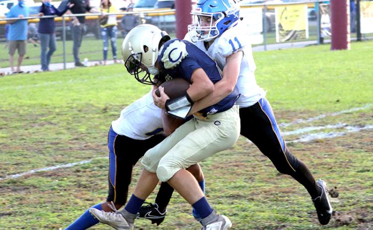 Fernandina Beach Middle School’s Devin Murray and Alex Pulwicz wrap up a Callahan Middle School football player Tuesday night in Callahan. AMANDA REAM/COMMUNITY NEWSPAPERS INC.