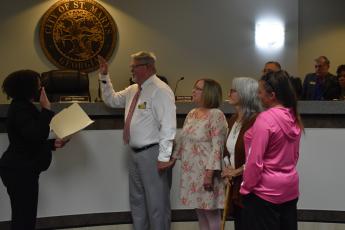 St. Marys City Clerk Deborah Walker-Reed, from left, issues the oath of office to newly elected  St. Marys Councilman Steve Conner. With Conner are his wife, Cheryl Conner, and the family of Danny Riggins, Anne Riggins and Dana Riggins Parker. Danny Riggins died in December after he was elected to the City Council.