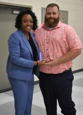 Camden County Superintendent Tracolya Green, left, presents the Teacher of the Year honor to Camden County High School’s Tyler Murray.