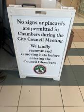Outside most St. Marys City Council meeting, this sign warns attendees that signs and placards are not allowed, and recommends hats be removed.